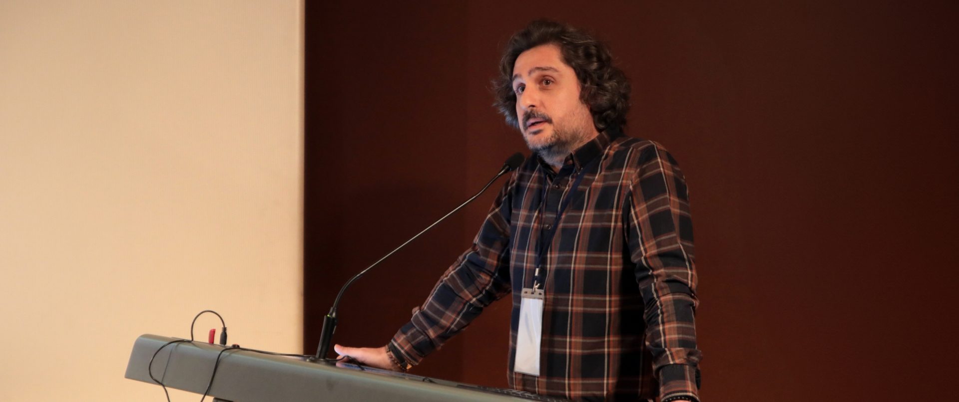 Orhan Erkut, bir kürsüde konuşma yaparken.