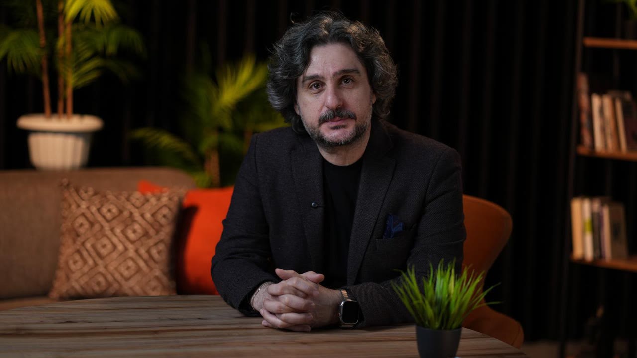 Orhan Erkut, bir kürsüde konuşma yaparken.